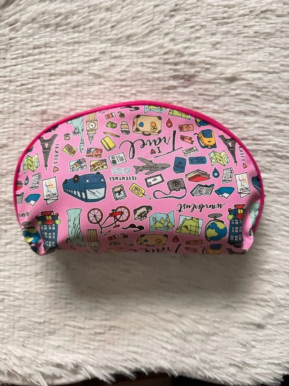 Pink travel-themed makeup bag zipper closure featuring travel-related doodles